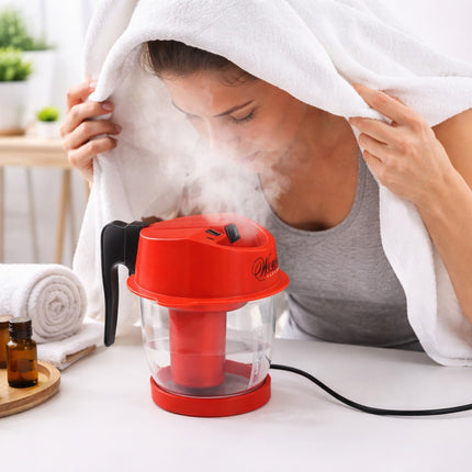 Person using a red facial steamer with steam rising, in a home setting.